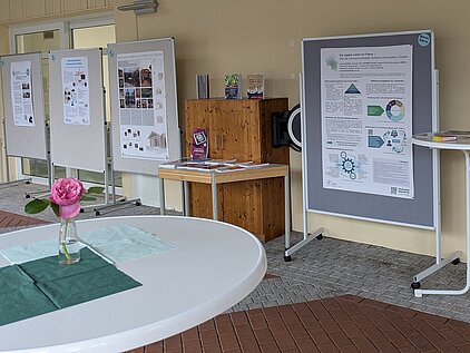 verschiedene präsentierte Poster stehen auf Stellwänden im Atrium, dazwischen Stehtische